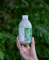 自然の中でシゼラスボディクリーム回生を手に持っている女性