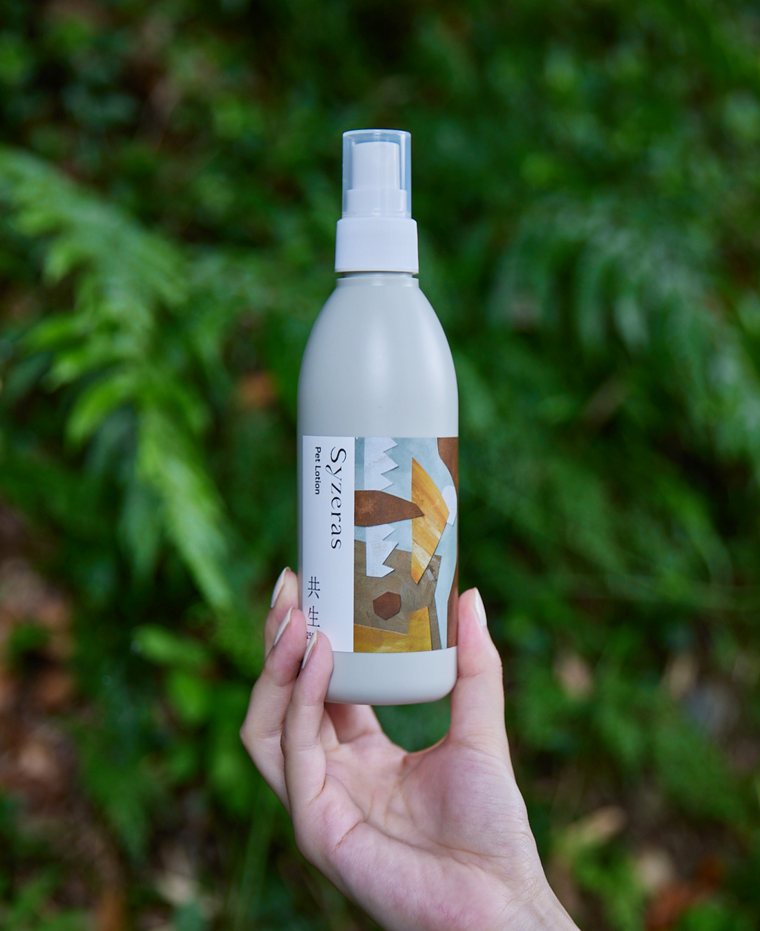 自然の中でシゼラスペットローション共生を手の甲にスプレーしている